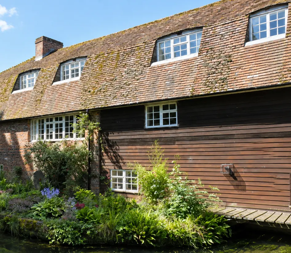The historic Town Mill building and riverside garden beside the River Test